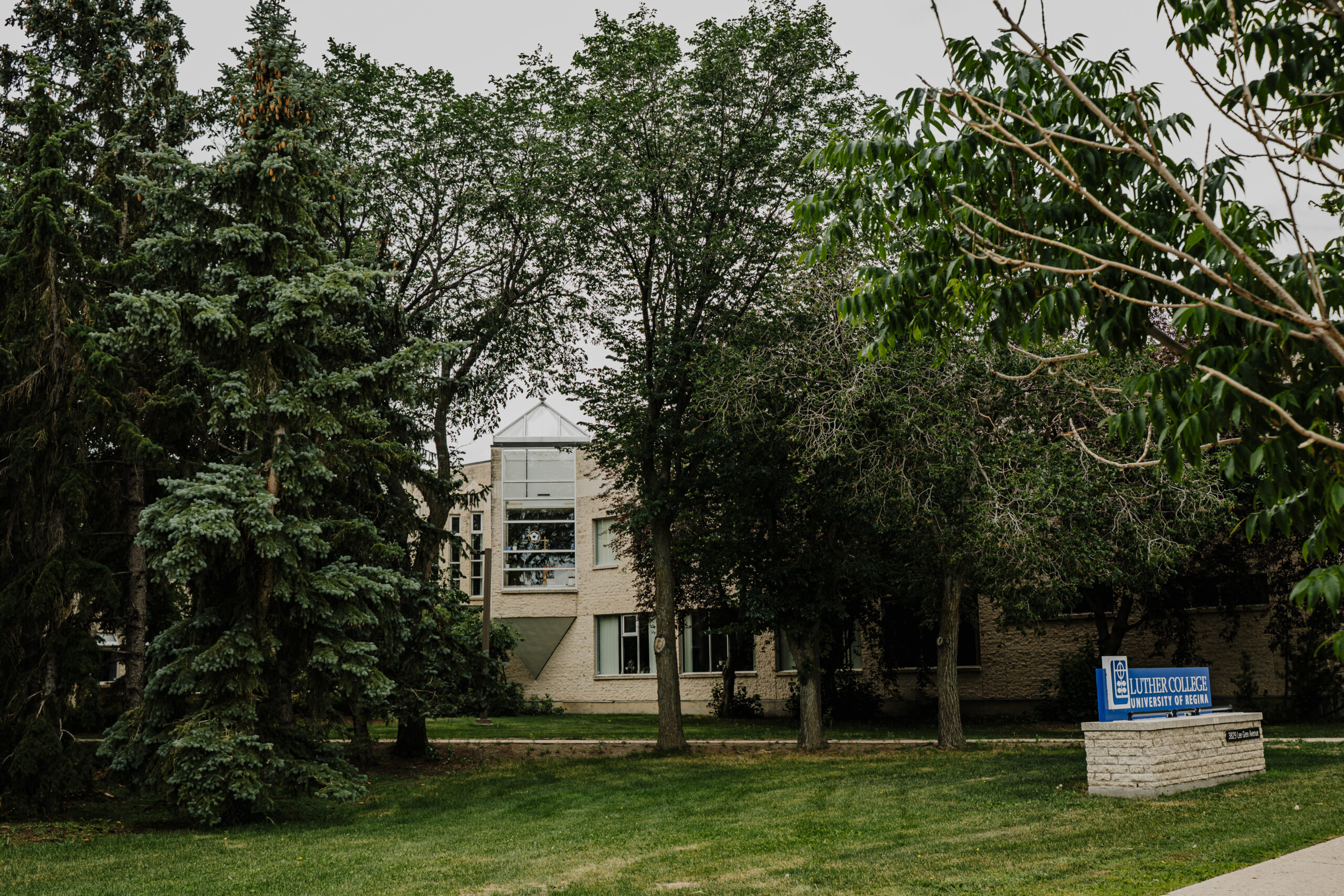 A photo of the exterior of Luther College at the University of Regina in Summer.